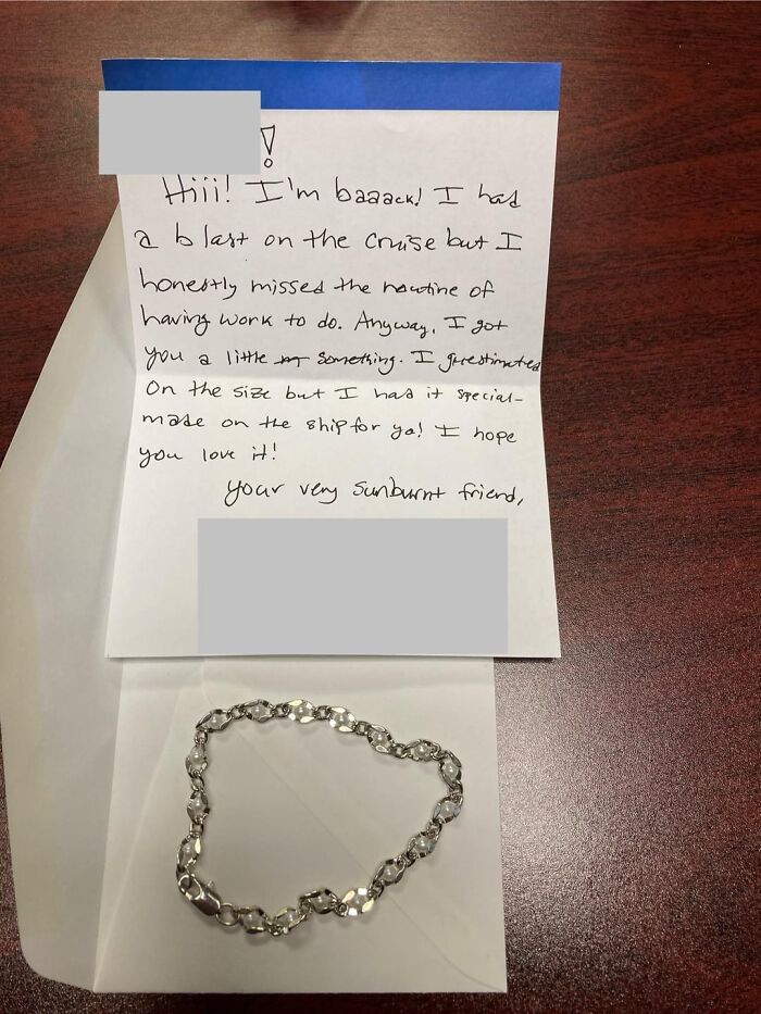 Handwritten letter and silver bracelet on wooden surface highlighting the beauty of planet Earth and thoughtful gifts.