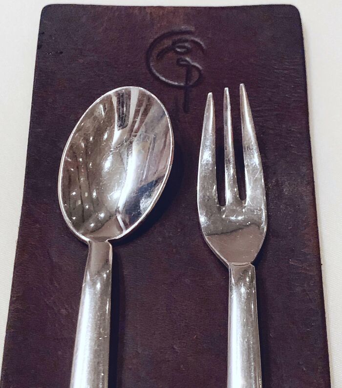 Silver utensil set with a spoon and fork on a dark leather surface showcasing a genius solution to overlooked problems