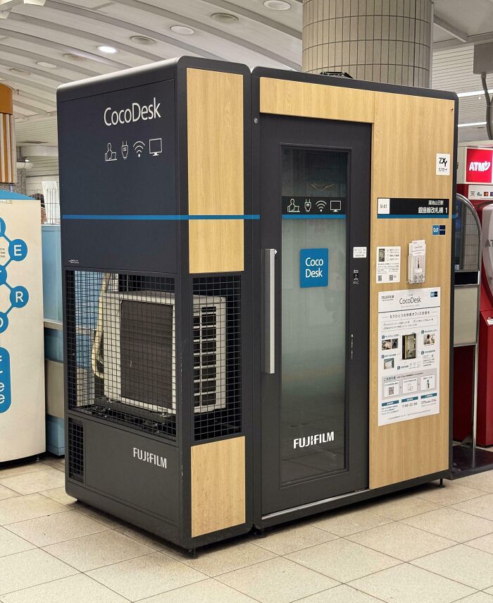 Compact CocoDesk workspace pod by Fujifilm in a public area offering privacy and connectivity for remote work sessions.