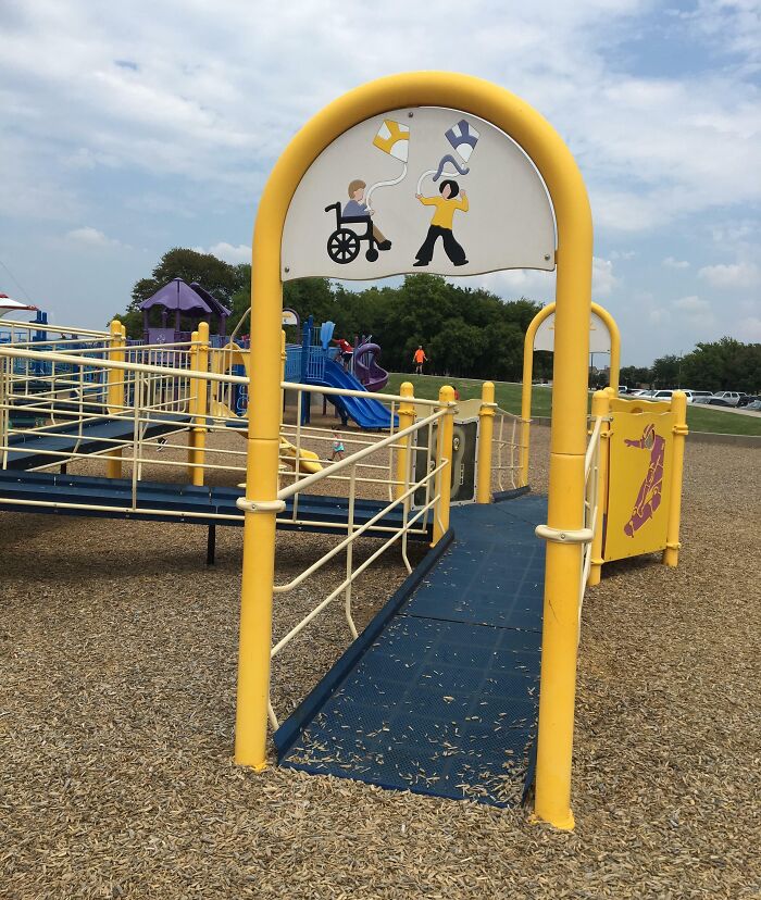 Accessible playground ramp with handrails and inclusive signage, showing genius solutions for overlooked problems.