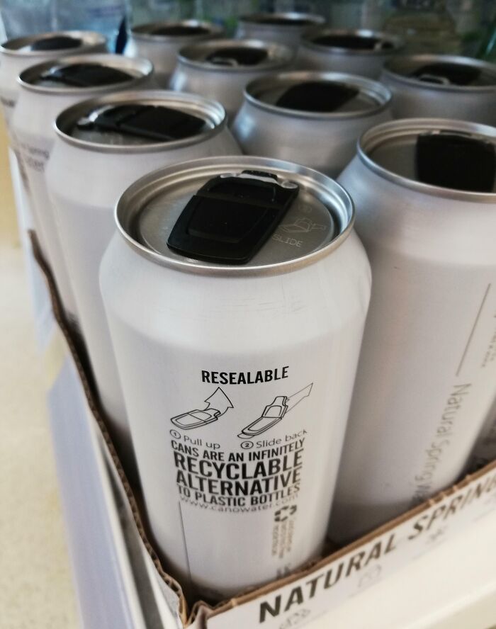 Resealable recyclable aluminum cans as a sustainable alternative to plastic bottles shown in a pack of natural spring water.