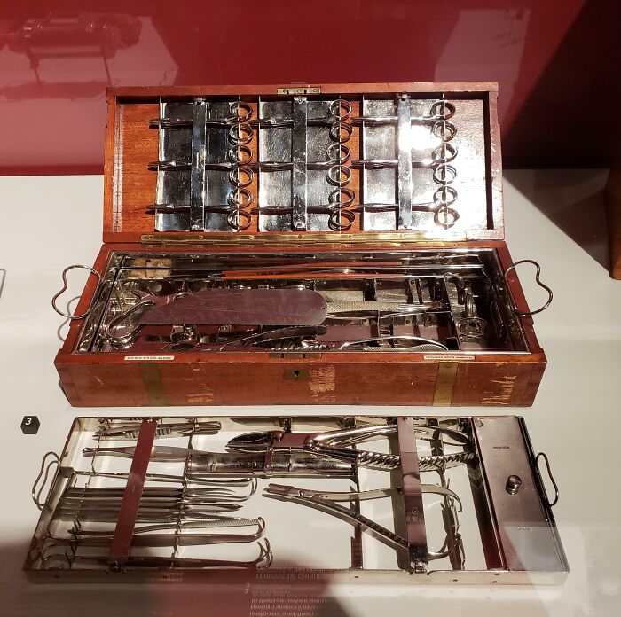 Vintage medical instruments displayed in a wooden case, showcasing fascinating and disturbing historical medical photos.