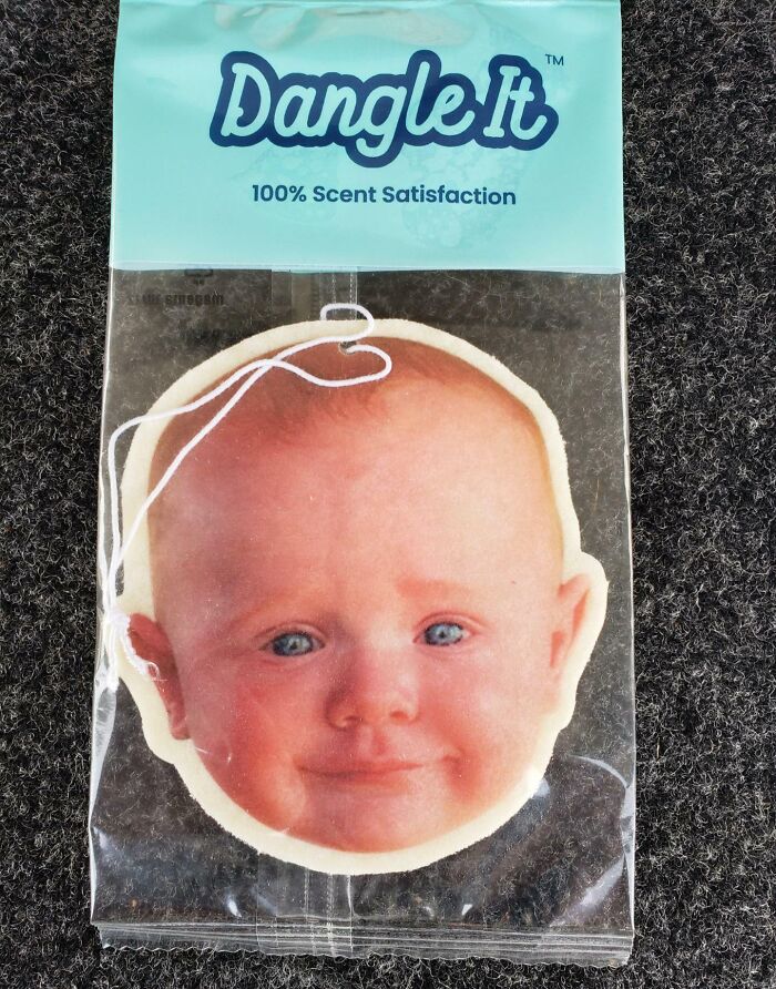 Air freshener with a baby face design labeled Dangle It, a funny dad gift for nailing fatherhood moments.