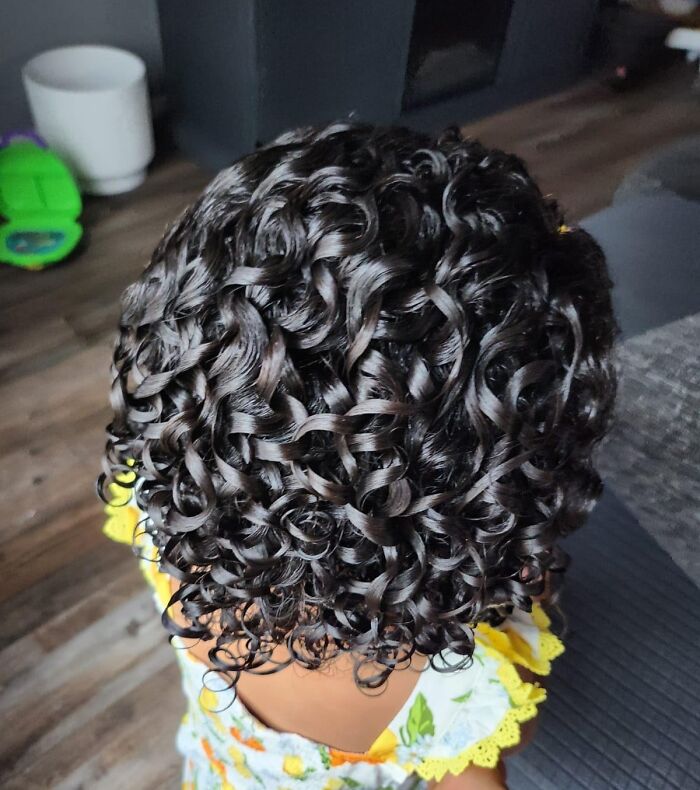 Curly hair with defined ringlets styled using low-effort products that help tackle high-anxiety body issues.
