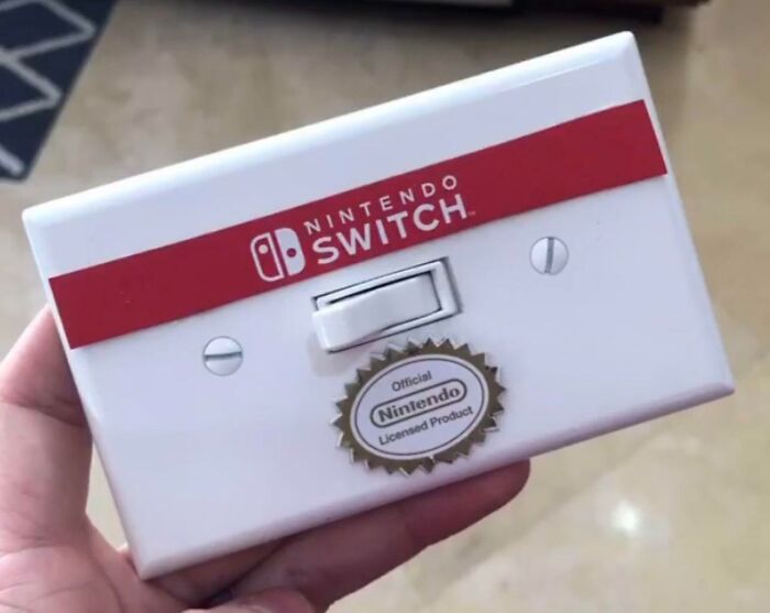 Hand holding a Nintendo Switch branded device resembling a retro game cartridge, showcasing creative dad humor.