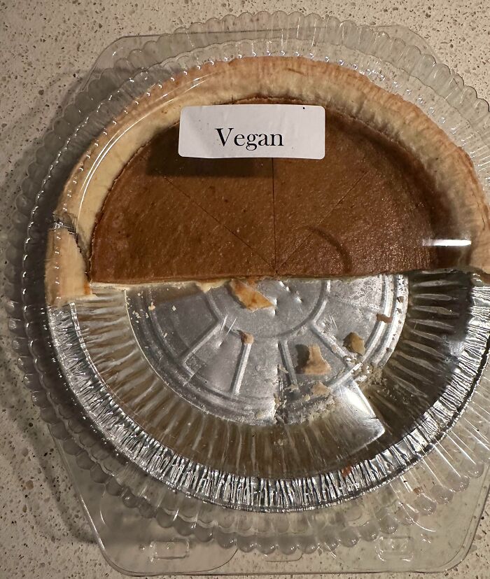 Half-eaten vegan pie in a plastic container, showcasing a dad's humorous approach to fatherhood and meal choices.