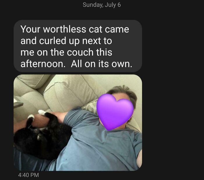 Dad lying on couch with a black cat curled up next to him showing hilarious dad moments in fatherhood.