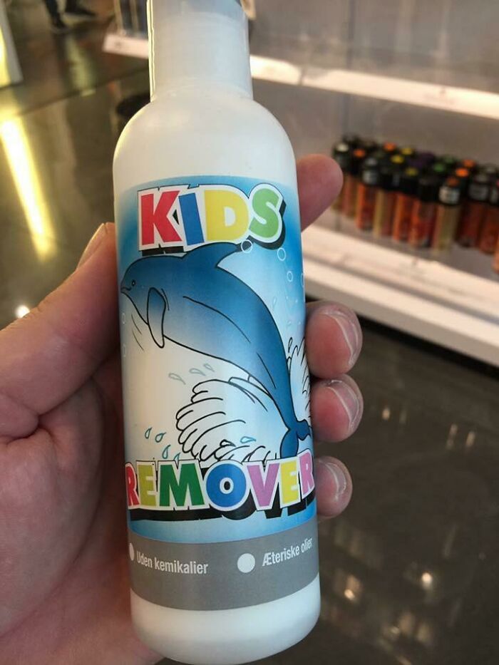 Hand holding a kids remover bottle with a dolphin illustration, highlighting hilarious dads nailing fatherhood humor.
