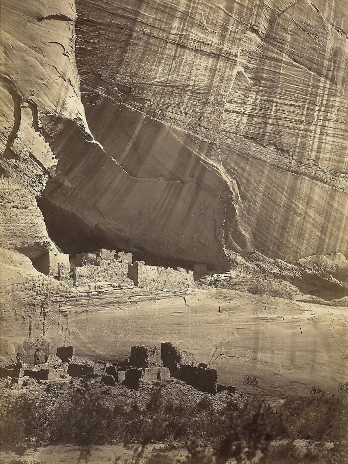 19th century photo showing ancient cliff dwellings built into rock face with sunlight streaming down history come alive