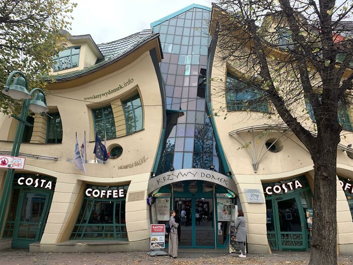 Unique crooked building with Costa Coffee in front, showcasing small genius things some countries do in urban design.