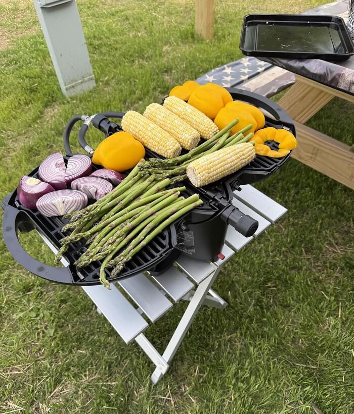 Compact portable grill with fresh vegetables cooking outdoors, one of the most wished for items burning up Amazon this week.