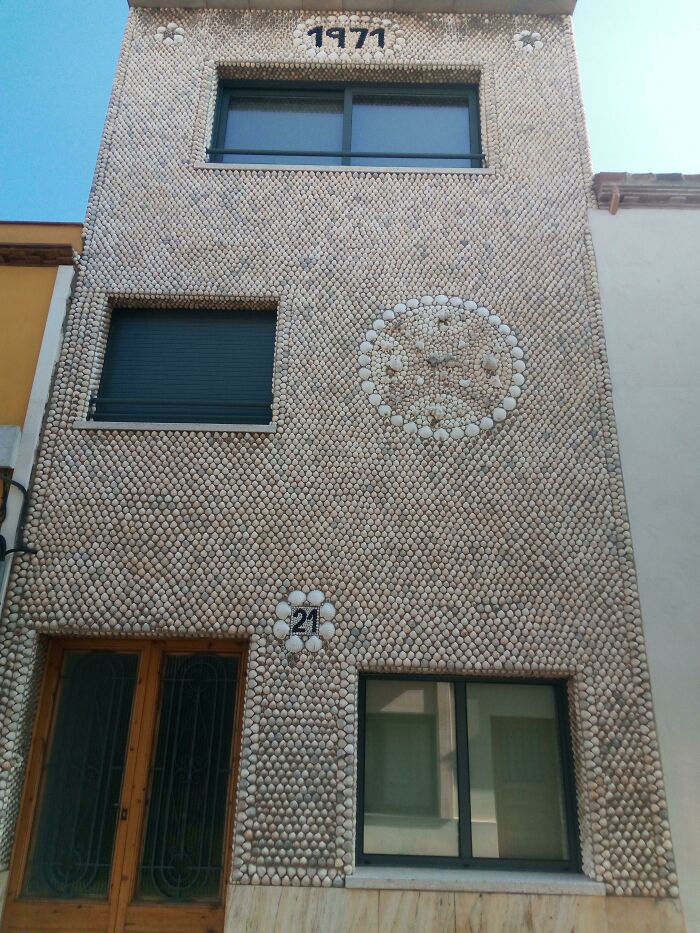 Facade of a house covered entirely in seashells, showcasing small but genius things some countries do for unique decoration.