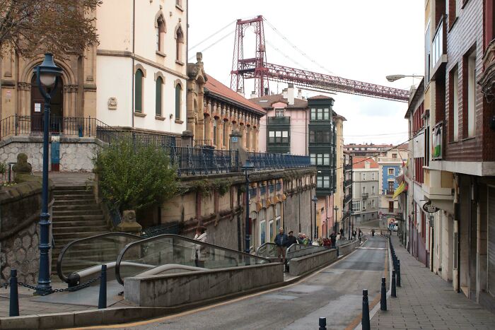 Street view of a small but genius urban design with accessible escalators in a historic European city.