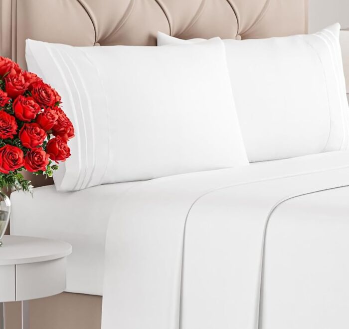 White bed sheets and pillowcases neatly arranged on a bed, one of the most wished for items on Amazon this week.