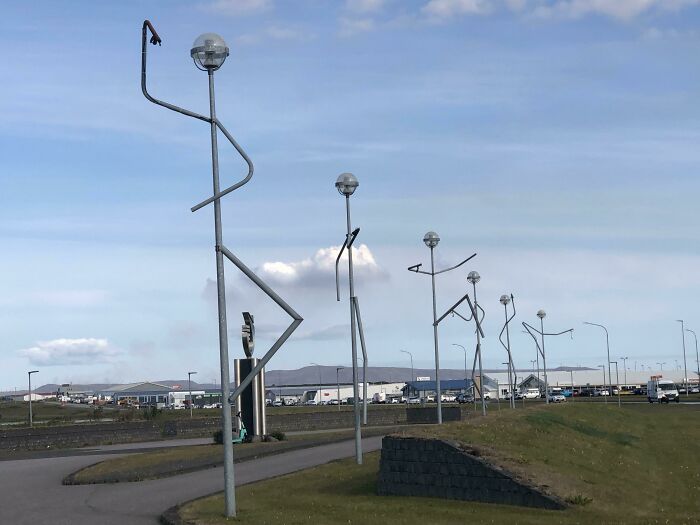 Creative street lamps shaped like stick figures lined along a pathway, showcasing small genius things some countries do.