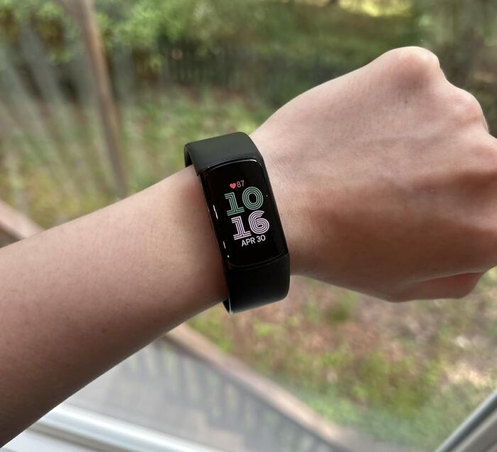 Fitness tracker smartwatch on wrist showing heart rate and time, one of the most wished for items burning up Amazon this week