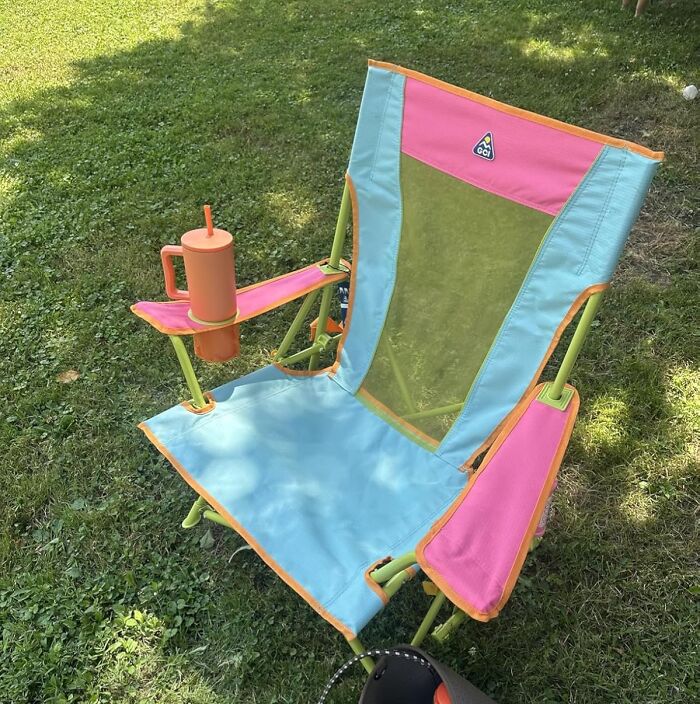 Colorful foldable outdoor chair with cup holder on grassy ground, one of the most wished for items on Amazon this week.