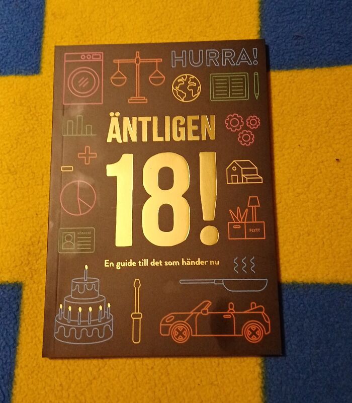 Book with colorful icons on a yellow and blue carpet, illustrating small genius things some countries do globally.