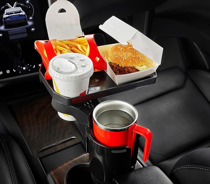 Car seat tray and cup holder organizer holding food and drinks, a popular item burning up Amazon this week.
