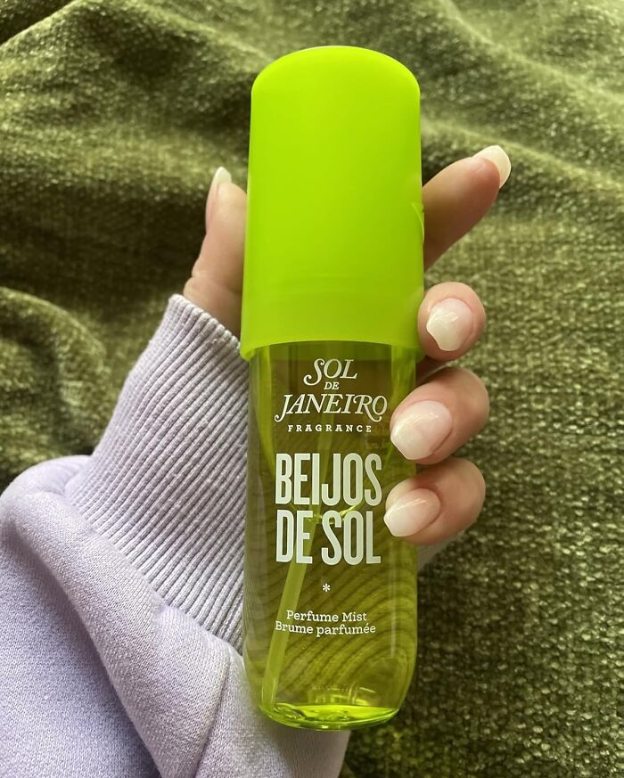 Hand holding Sol de Janeiro Beijos de Sol perfume mist, one of the most wished for items burning up Amazon this week
