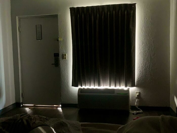 Dark hotel room with curtains blocking light poorly, showcasing one of many times hotels messed up badly for guests.