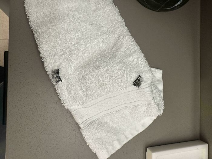 White hotel towel with fake eyelashes stuck on it, showing a humorous hotel mess-up from poor housekeeping.