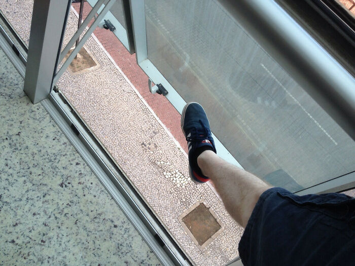 Person's leg dangerously stretched out a broken hotel balcony window, showing a serious hotel safety mess up.