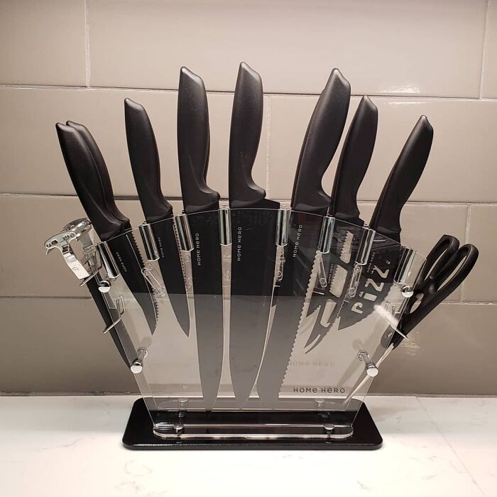 A set of genuinely brilliant kitchen items including knives and scissors in a clear acrylic knife block on a countertop.