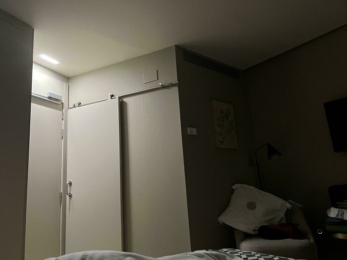 Dimly lit hotel room showing a sliding door not fully closed, illustrating one of the many hotel mess ups vented online.