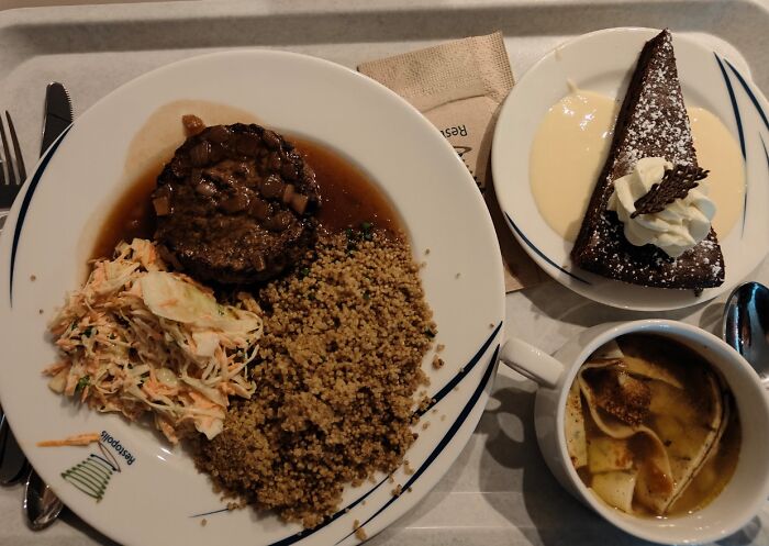 Plate with seasoned couscous, mushroom gravy, coleslaw, chocolate dessert with cream, and cup of soup showcasing small genius food ideas.