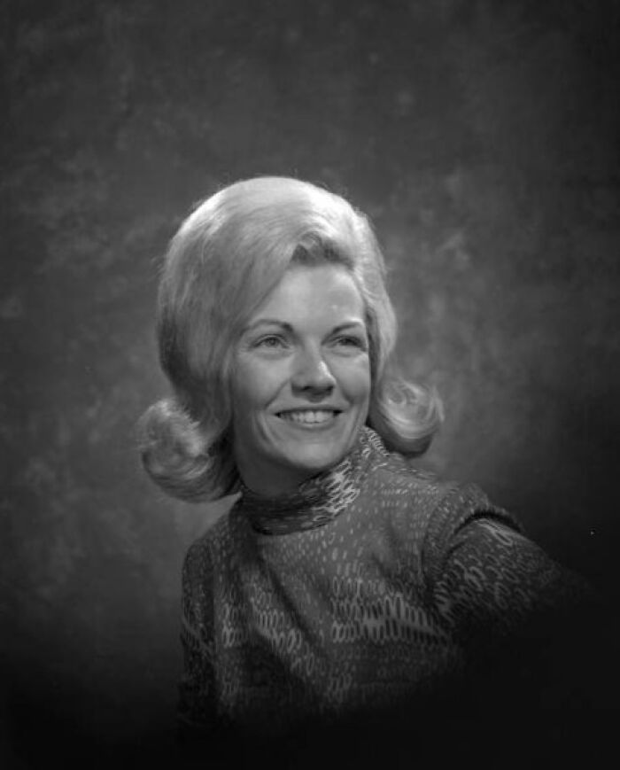 Black and white portrait of a woman in Florida breaking barriers in the 1970s, smiling with styled blonde hair.