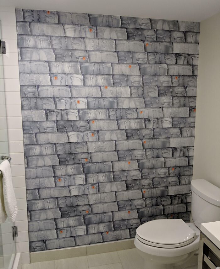 Bathroom wall covered with denim jeans wallpaper, an unusual hotel design mistake from people venting online.