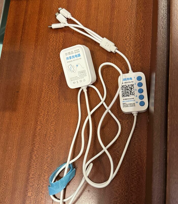 Charge cables with multiple connectors and confusing labels on a wooden surface, an example of hotel mess ups online.