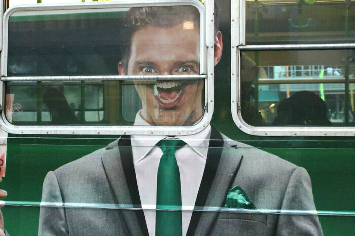 Advertising fail showing unattainable body with distorted face on a bus window, creating a funny visual effect.