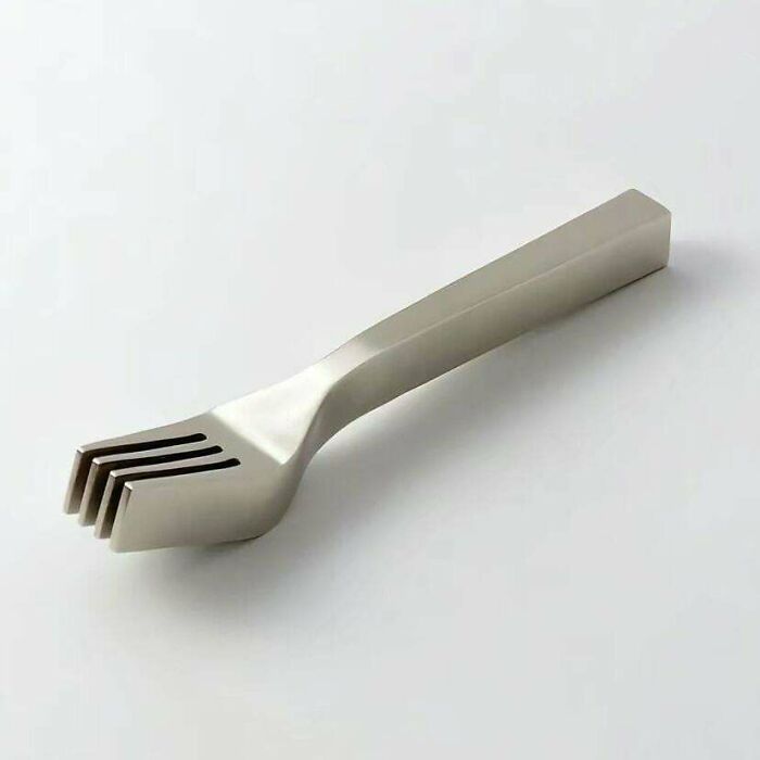 Unusual metal fork design with four separate prongs stacked together, showcasing extraordinary and fascinating things.