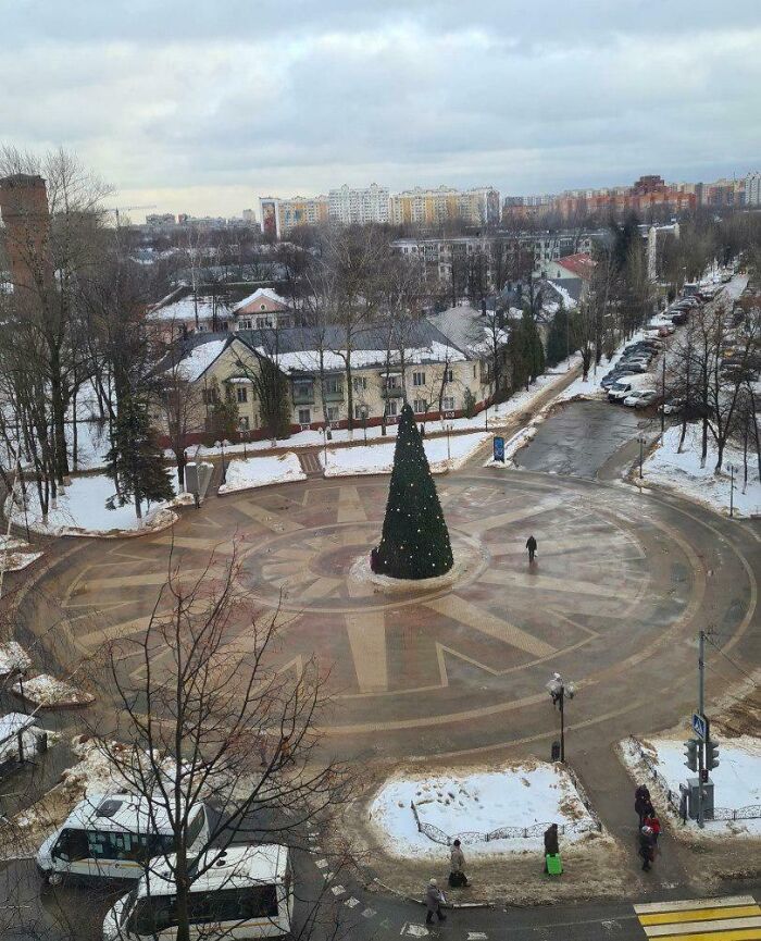 Roundabout with a Christmas tree slightly off-center, surrounded by muddy snow, illustrating imperfect things that may annoy people with OCD.