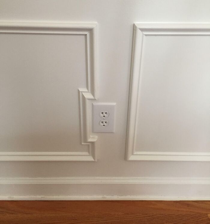 Mismatched wall paneling design around an electrical outlet, highlighting imperfect details that annoy people with OCD.