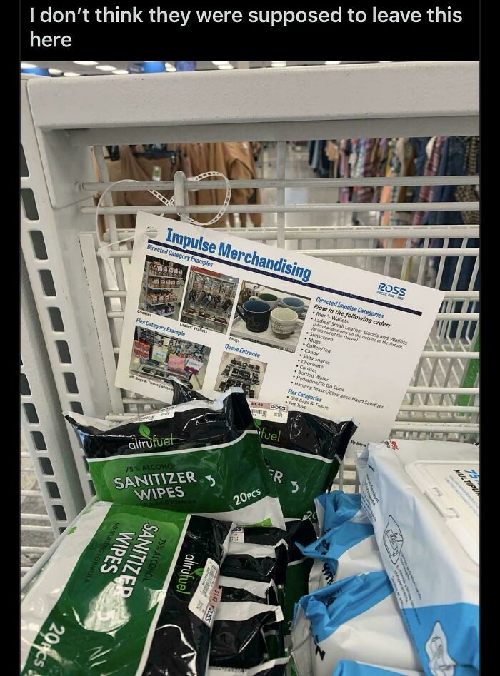 Impulse merchandising sign with sanitizer wipes and cleaning products left on a store shelf highlighting consumerism trends.