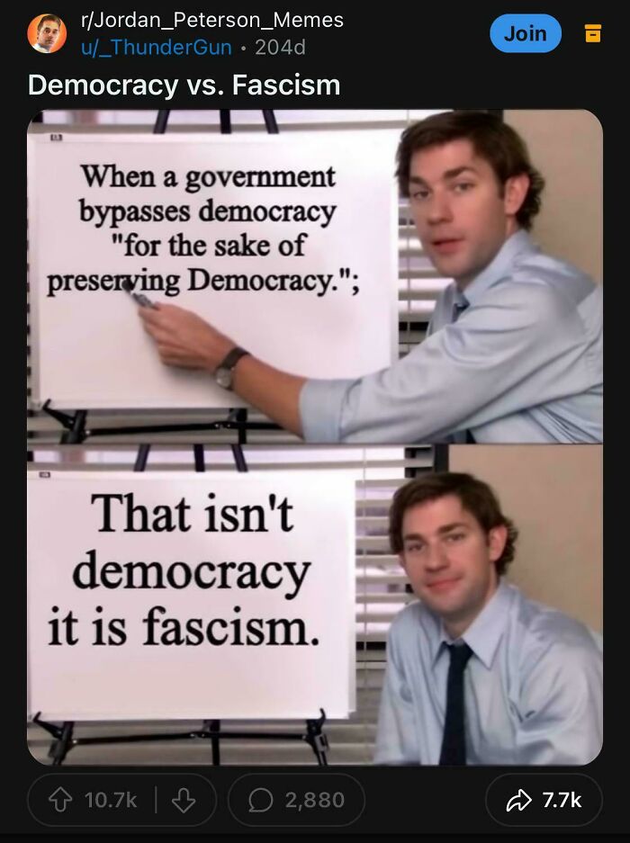 Man presenting the contrast between democracy and fascism on a whiteboard, illustrating accurate political predictions.