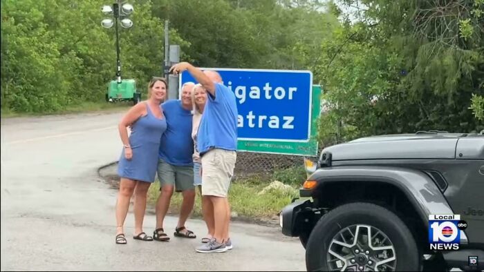 Group of people taking a casual photo near a road sign with a jeep, capturing a moment of modern life in a boring dystopia.