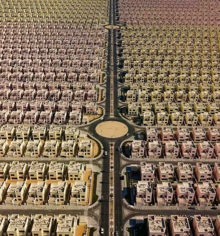 Aerial view of a $58 billion ghost city showing rows of empty houses and deserted streets in an urban hell landscape.