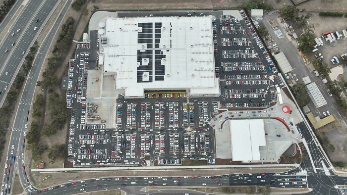 Aerial view of a large parking lot and buildings in a $58 billion ghost city showcasing urban development and empty spaces.