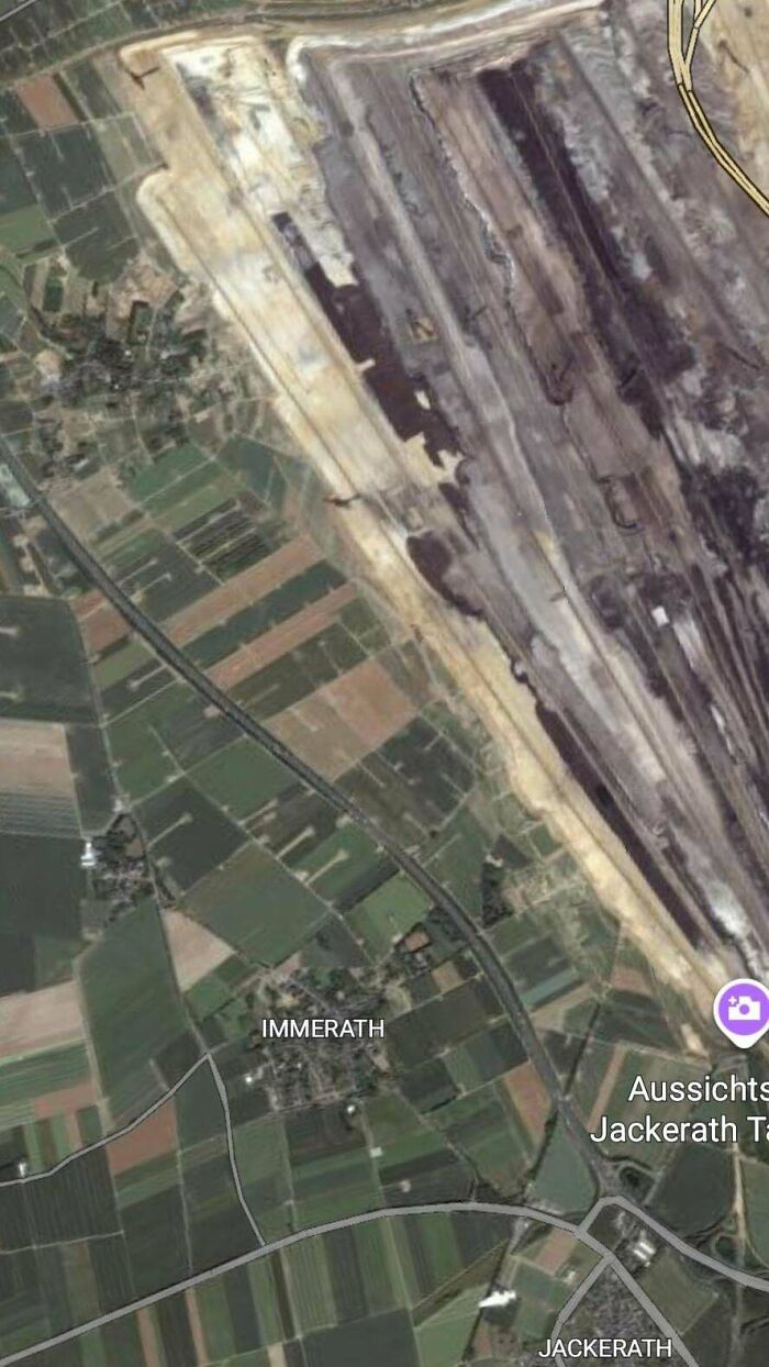 Aerial view of urban hell showing large-scale environmental damage and land destruction near agricultural fields.