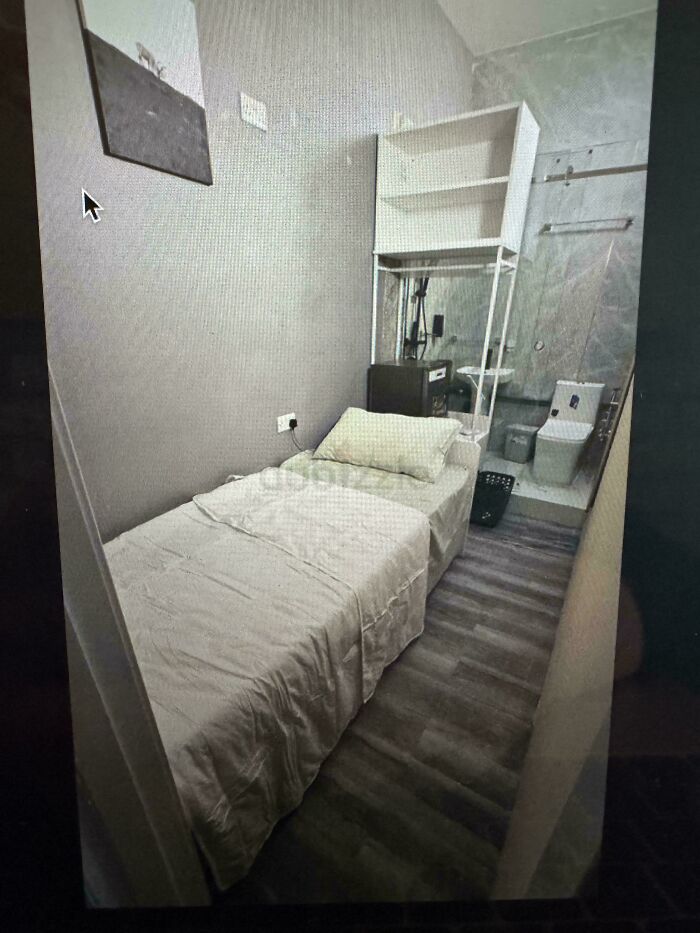 Small, narrow bedroom in $58 billion ghost city apartment, featuring a single bed and compact bathroom in cramped urban living space.