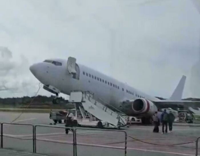 Airplane tilted nose-up on the tarmac with open doors, an accident that looked expensive.