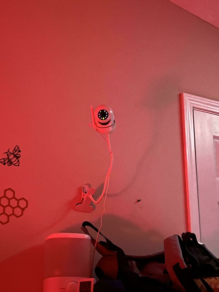 Baby monitor camera mounted on a red-lit wall, capturing wholesome parenting moments for dads doing their best.