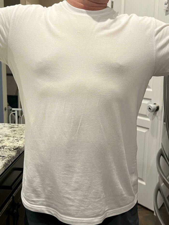 Man in a white shirt showing a heartfelt parenting moment in a home kitchen, highlighting dads doing their best.