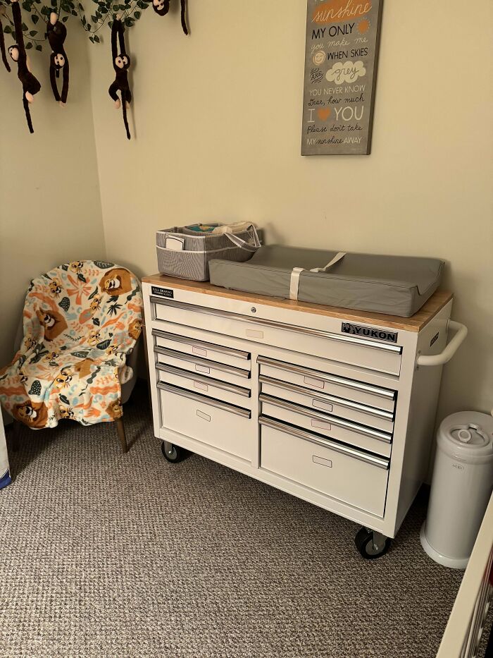 Organized nursery corner with a changing station and storage, showcasing dads doing their best parenting moments.