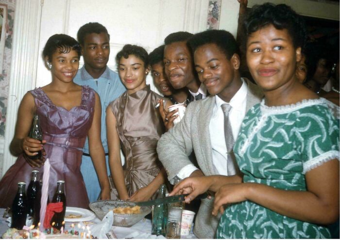 Group of young people dressed in vintage clothing enjoying a social gathering in candid glimpses into the past.