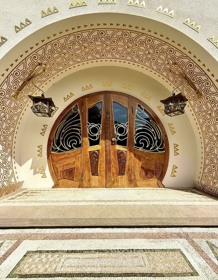 Ornate wooden door with intricate glass and geometric archway showcasing impressive architectural feats and detailed craftsmanship.